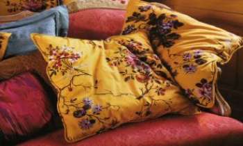 1653 | Sofa - Une invite à la relaxation : de moelleux coussins sur un sofa au précieux tissu damassé.